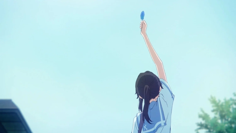 Nozomi raising a blue feather toward the sky