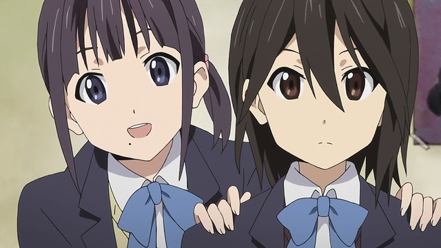 Two female students, Iori Nagase and Himeko Inui, from the anime Kokoro Connect are shown together wearing their school uniforms.